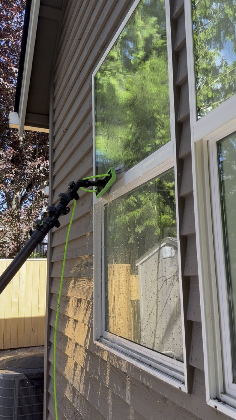 Window cleaning at roofline on Portland residential home