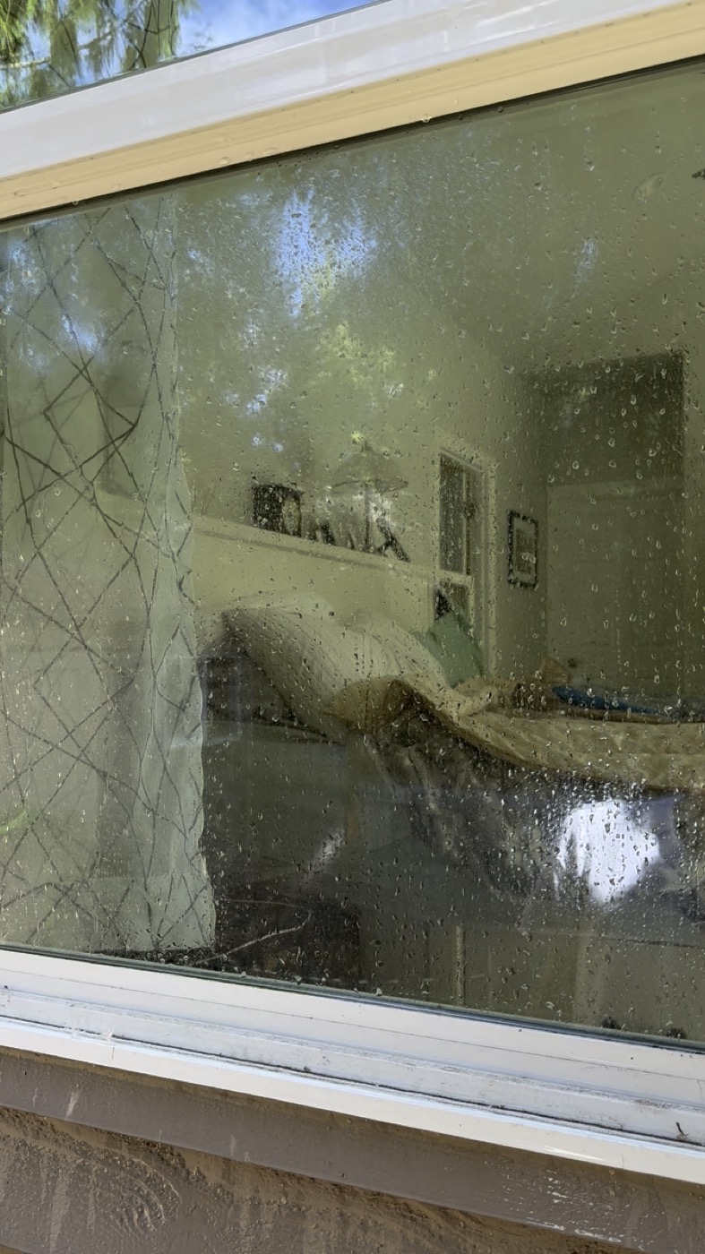 Dirty window before professional cleaning — water spots and grime on Portland home